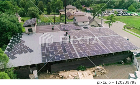 Workers installing PV solar panels on the roof of a house,which converts solar energy into electric energy. Concept of work. Workers in special outfit walk and talk about sunny cells installation. Workers installing PV solar panels on the roof of a house,which converts solar energy into electric energy. Concept of work. Workers in special outfit walk and talk about sunny cells installation. 120239798