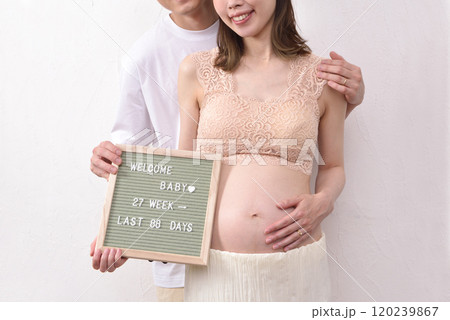 レターボードを持って若い妊婦と寄り添う夫 120239867