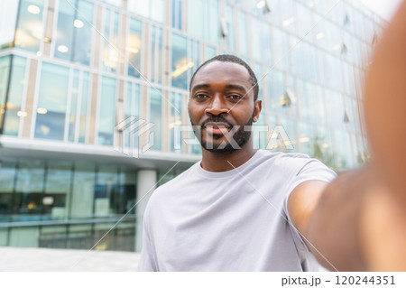 African American man with smartphone having video call on street in city. Guy blogger streaming chatting in social network. Man having virtual meeting vlog online chat outdoor Selfie webcamera view 120244351