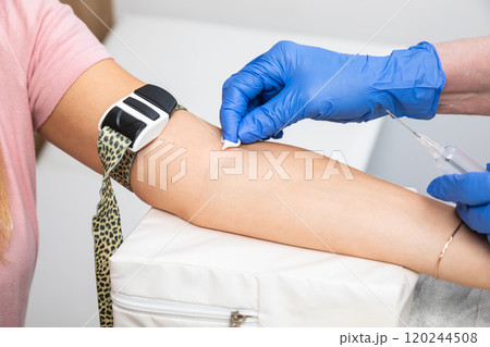 Nurse preparing patients arm for taking blood sample 120244508