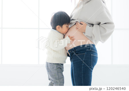 屋内の自然光豊かなスタジオで臨月のお母さんのお腹にキスして幸せそうな表情をする子どものマタニティフォ 屋内の自然光豊かなスタジオで臨月のお母さんのお腹にキスして幸せそうな表情をする子どものマタニティフォ 120246540