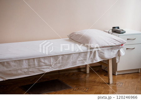 A Neatly Arranged Massage Table with Pillow in a Serene Therapy Room A Neatly Arranged Massage Table with Pillow in a Serene Therapy Room 120246966