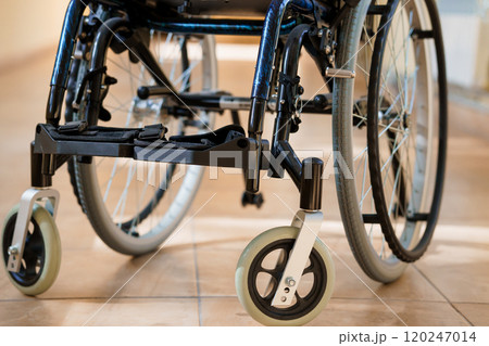 Wheelchair in a Well-Lit Corridor with Focus on Wheels and Frame Wheelchair in a Well-Lit Corridor with Focus on Wheels and Frame 120247014