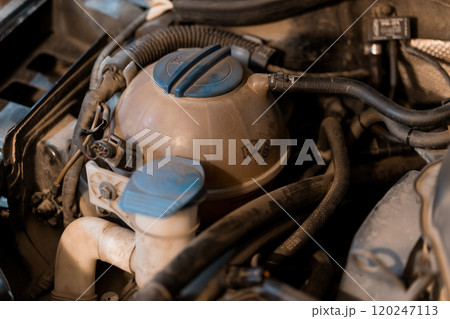 Close-up of a Car's Engine Coolant Reservoir with Surrounding Components Close-up of a Car's Engine Coolant Reservoir with Surrounding Components 120247113