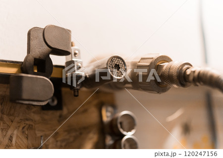 Close-Up of a Metal Pipe Fitting and Clamp in a Workshop Setting Close-Up of a Metal Pipe Fitting and Clamp in a Workshop Setting 120247156