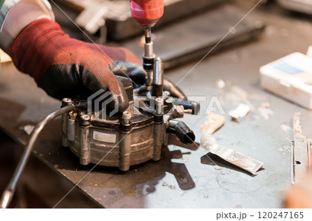 Mechanical Technician Assembling a Fuel Pump Component in a Workshop 120247165