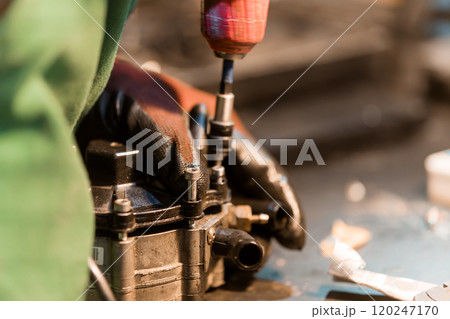 Precision Engineering: A Technician Assembles an Automotive Component with Careful Attention to Detail 120247170