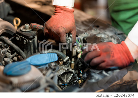 Mechanic Performing Engine Repairs in Automotive Workshop 120248074