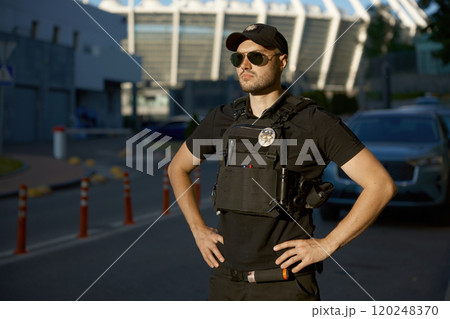 Portrait of confident male patrol police officer standing outdoors 120248370