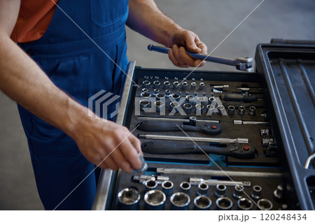 Closeup high angle view on tool box and male mechanic hands taking wrench 120248434