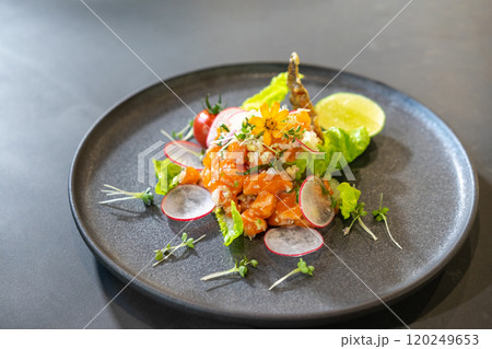 Spicy Raw Salmon Salad Thai food style decorated with Crispy fried fish skin and Yellow Flower on top and micro herb around dish. Ready to serve and eat. Spicy Raw Salmon Salad Thai food style decorated with Crispy fried fish skin and Yellow Flower on top and micro herb around dish. Ready to serve and eat. 120249653