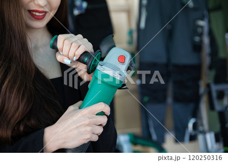 A young woman meticulously using a power tool within a wellequipped workshop environment A young woman meticulously using a power tool within a wellequipped workshop environment 120250316
