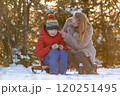 Young woman with son in winter forest on picnic drink hot tea in warm light. Happy family spends weekends outside the city. 120251495