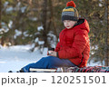 Portrait of boy in warm blown jacket knitted hat with cup of hot tea in winter forest. Picnic in winter in nature. 120251501