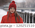 Portrait of a young girl in a red jacket on a background of winter landscape 120251510