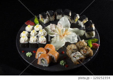 Seth sushi on a black background.Menu of the Japanese restaurant. Several sushi close-ups are beautifully laid out on a plate. Traditional Asian food Seth sushi on a black background.Menu of the Japanese restaurant. Several sushi close-ups are beautifully laid out on a plate. Traditional Asian food 120252354