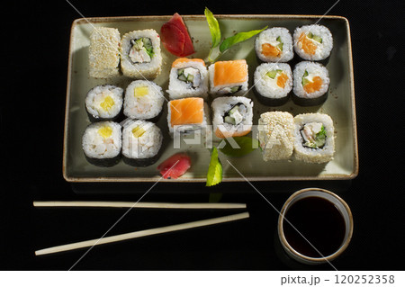 Menu of the Japanese restaurant. Several sushi lined on a plate with bamboo sticks and soy sauce.View of the rolls from above Menu of the Japanese restaurant. Several sushi lined on a plate with bamboo sticks and soy sauce.View of the rolls from above 120252358