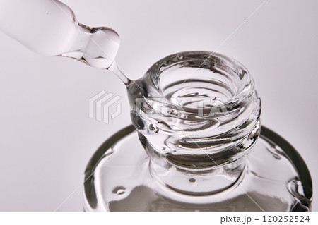 Close-up of a cosmetic bottle with a pipette showing the texture of the serum. 120252524