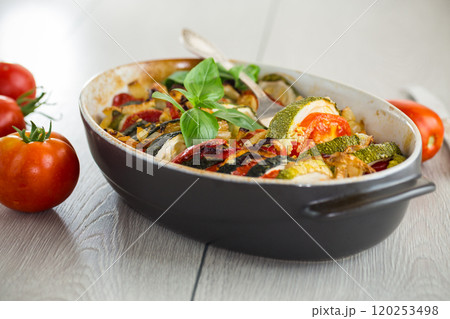 prepared baked zucchini and tomatoes in circles in a ceramic form, vegetable snack 120253498