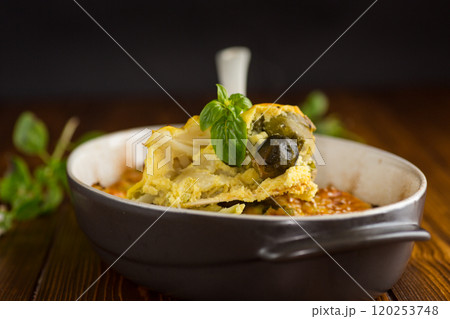 cauliflower and brussels sprouts casserole with cheese, in a ceramic dish on a wooden table 120253748