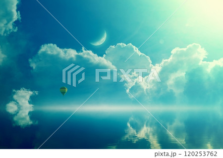 Amazing heavenly image - crescent and hot air balloon rising above serene sea, light from heaven. 120253762