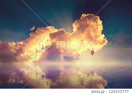 Amazing heavenly image, crescent, pink clouds and hot air balloon rising above serene sea, light from heaven. 120253777