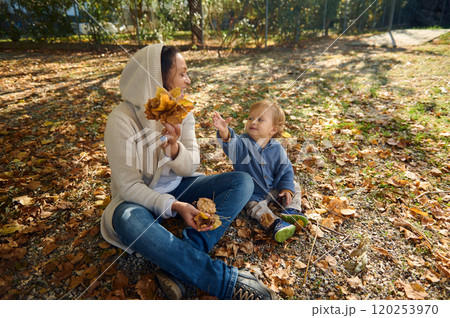 Mother and child enjoying a playful autumn day outdoors 120253970