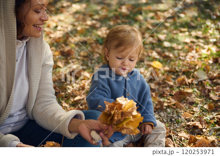 Mother and child enjoying autumn leaves together in the park Mother and child enjoying autumn leaves together in the park 120253971