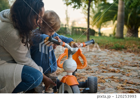 Mother bonding with child outdoors on a tricycle ride 120253993