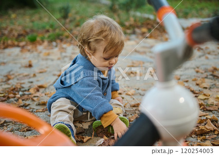 Young child playing on an autumn day in a cozy sweater Young child playing on an autumn day in a cozy sweater 120254003