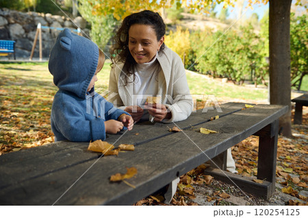 Mother and child enjoying a sunny autumn day in the park Mother and child enjoying a sunny autumn day in the park 120254125