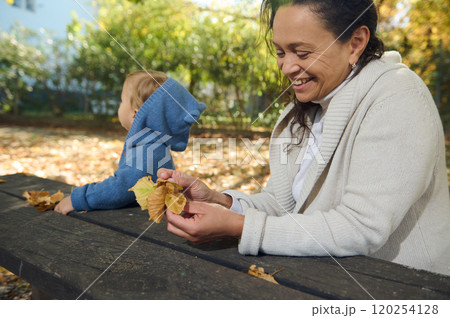 Grandmother and grandson enjoying autumn day in the park together Grandmother and grandson enjoying autumn day in the park together 120254128