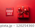 Red gift box on a red paper background with a red bow. BLACK FRIDAY inscription. Mockup, top view 120254360