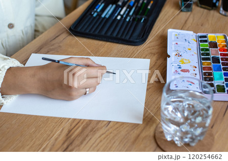 Artist Starting a Watercolor Painting on a Blank Canvas 120254662