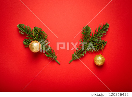 Christmas decoration on red background creating festive atmosphere, fir branches creating a shape of deer antlers 120256432