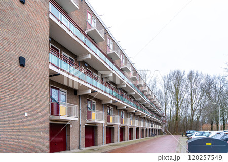 Front view of apartment house with red awnings, Netherlands. Protection against sunlight, rising temperatures and heat waves in summer season Front view of apartment house with red awnings, Netherlands. Protection against sunlight, rising temperatures and heat waves in summer season 120257549