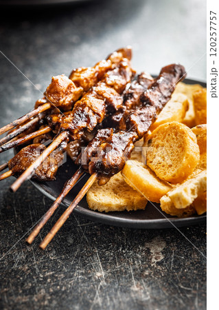 Japanese chicken yakitori and roasted bread on black table. 120257757
