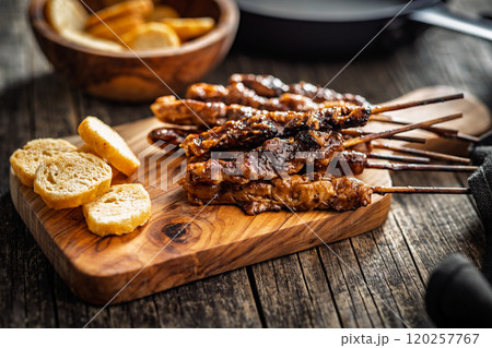 Japanese chicken yakitori on cutting board on wooden table. Japanese chicken yakitori on cutting board on wooden table. 120257767