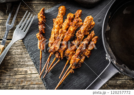 Japanese chicken yakitori on cutting board on wooden table. Top view. Japanese chicken yakitori on cutting board on wooden table. Top view. 120257772