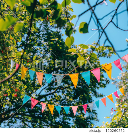 Colorful Bunting Flags Hanging in a Tree Against a Blue Sky 120260252
