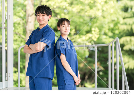 病院・施設の前にいるスクラブをきた医療従事者の男女スタッフ（作業療法士・看護師） 120262894