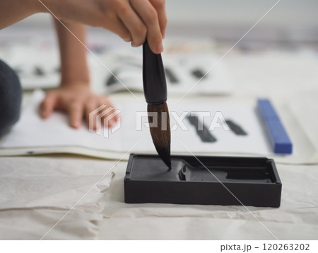 書き初め（大筆で漢字を書く子供の手） 120263202