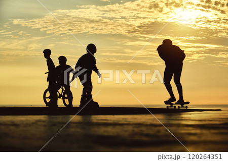 Silhouette of young jumping skateboarder riding longboard, summer sunset background. Culture Enjoy Sports Vacation 120264351