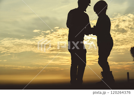 Silhouette of father and son training in saktepark rollerblading, summer sunset background. Culture Enjoy Sports Vacation 120264376