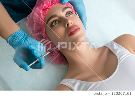 Girl in a disposal cap at lip beauty injection 120267161