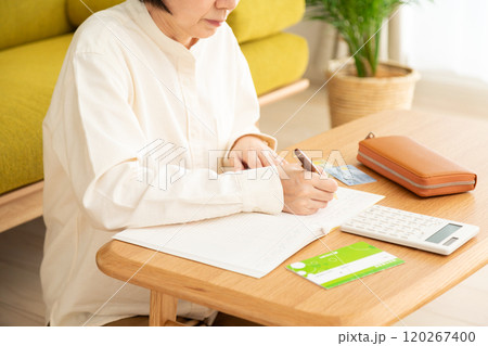 家計簿をつけるミドル〜シニア女性の手元 家計簿をつけるミドル〜シニア女性の手元 120267400