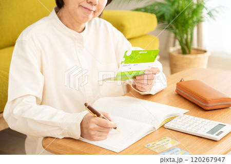 家計簿をつけながら悩むミドル〜シニア女性 家計簿をつけながら悩むミドル〜シニア女性 120267947