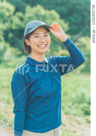 青いポロシャツと青いキャップ姿の働く女性 青いポロシャツと青いキャップ姿の働く女性 120268738