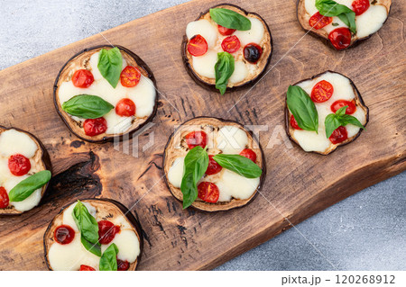 Italian mini pizza . Aubergine (eggplant ) with mozzarella cheese and basil . On rustic background 120268912