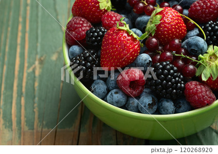 Mix of ripe colorful berries in bowl photography . Blueberry , strawberry , raspberry , blackberry and red currant . Top view 120268920